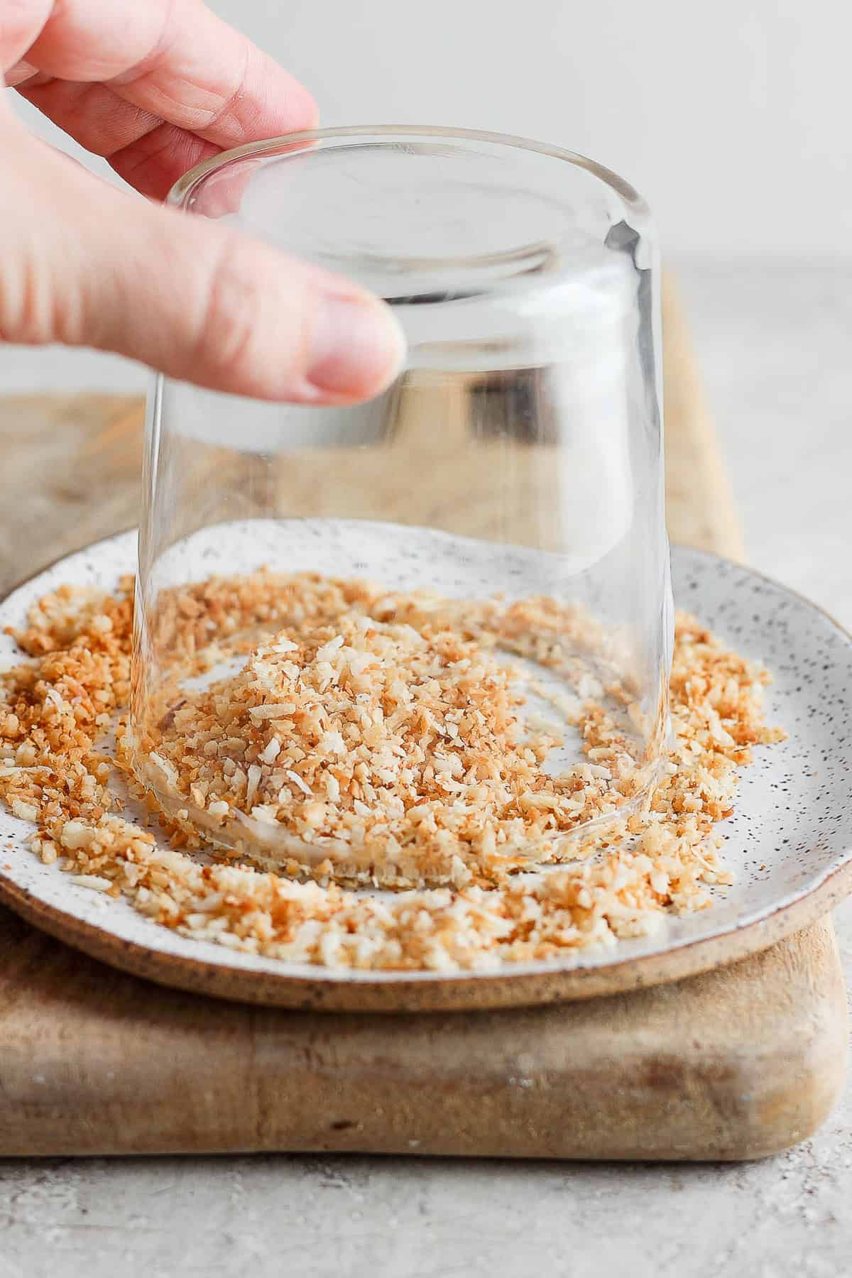 Preparing a glass with coconut flakes for the rim