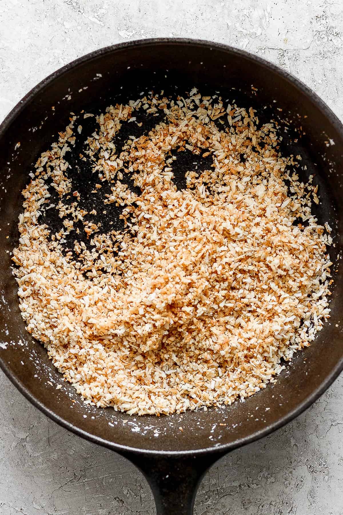 Toasted coconut flakes in a large skillet