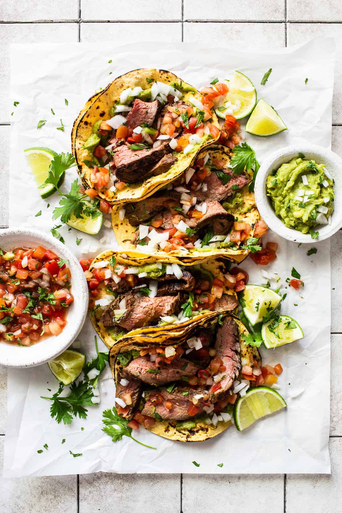 Flank steak tacos served with toppings. 