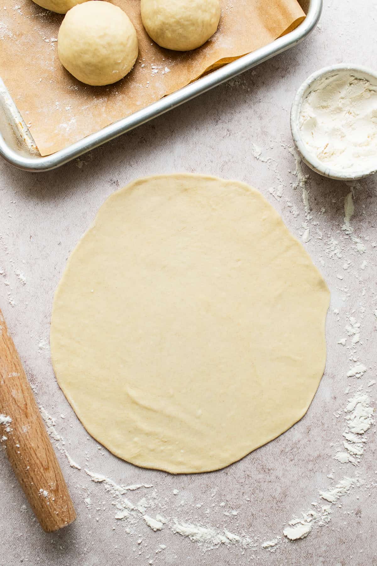 Flour tortilla dough ball rolled out into a circle