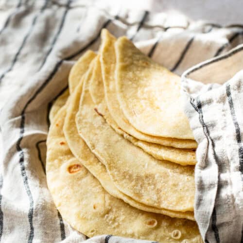 Homemade flour tortillas in a clean kitchen towel.
