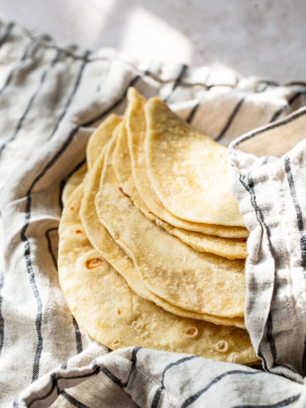 Homemade flour tortillas in a clean kitchen towel.