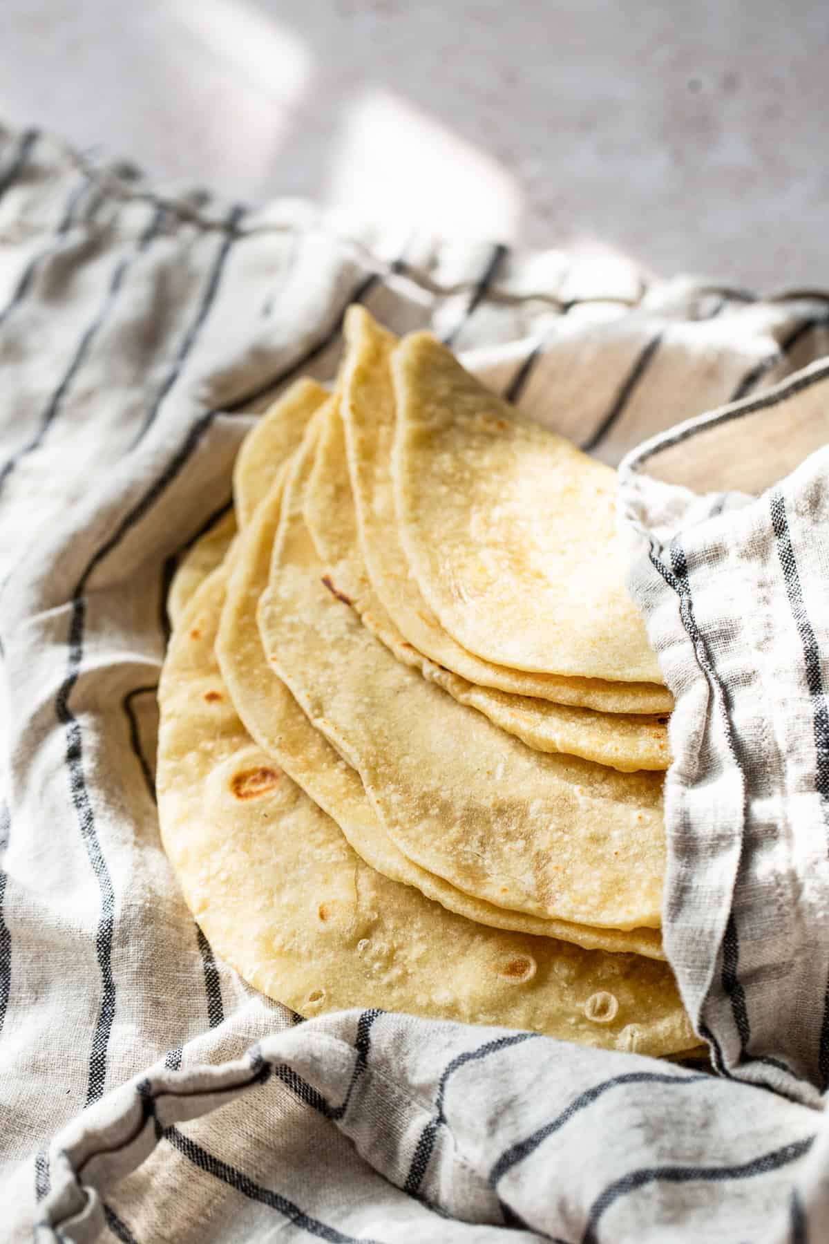 Flour tortillas in a clean kitchen towel ready to eat