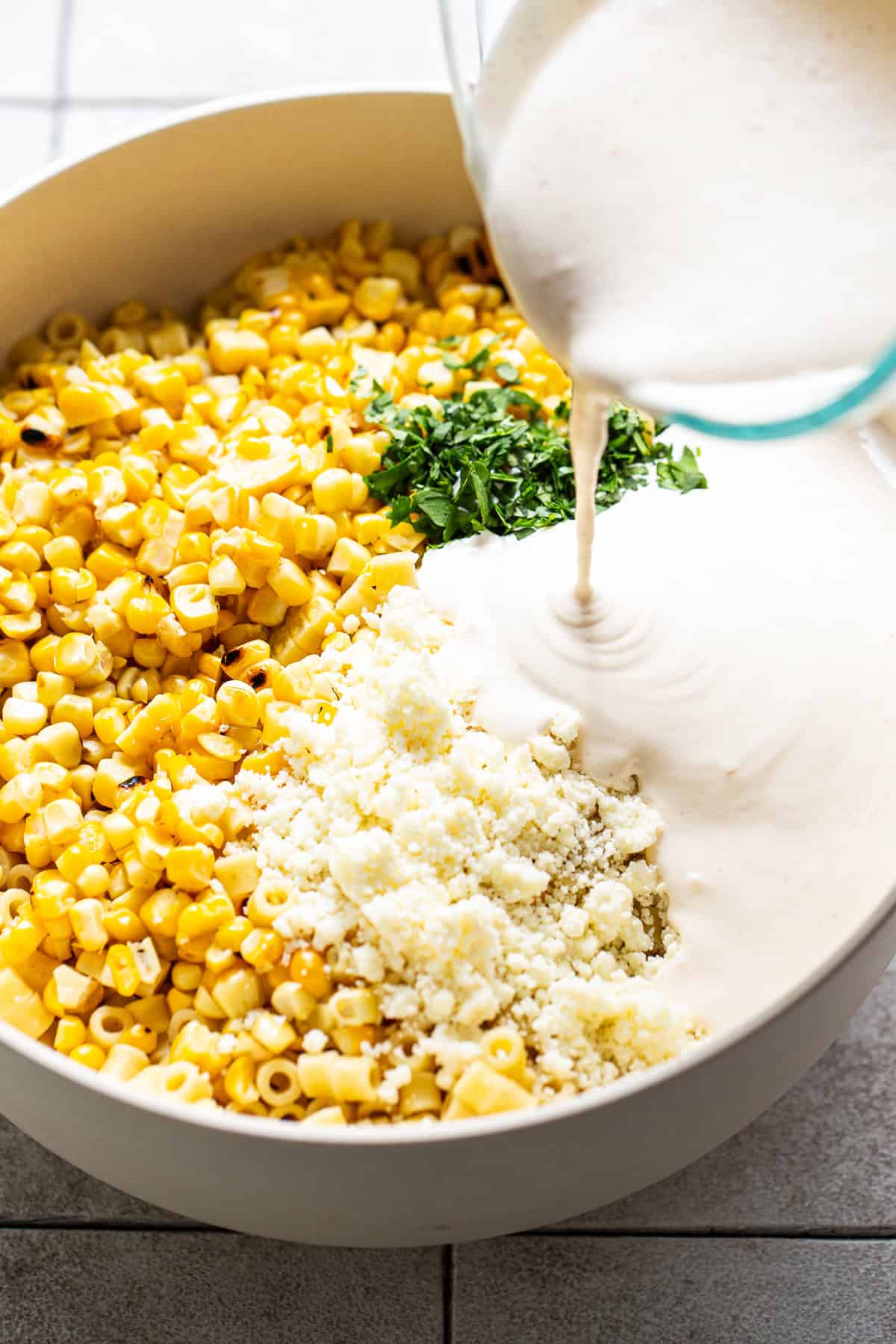 Mexican street corn pasta salad being assembled in a large mixing bowl.