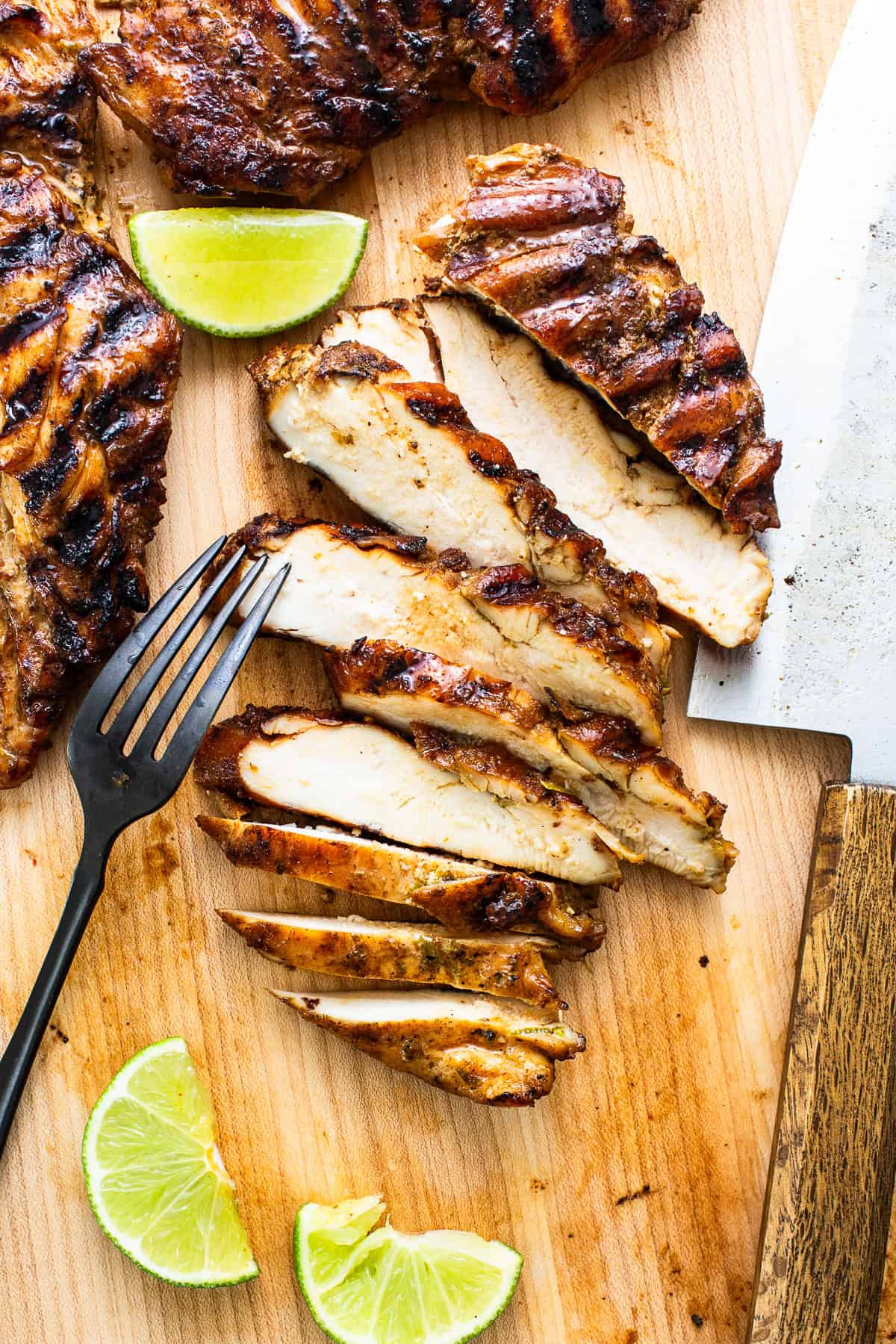 Grilled chicken cut into slices on a cutting board