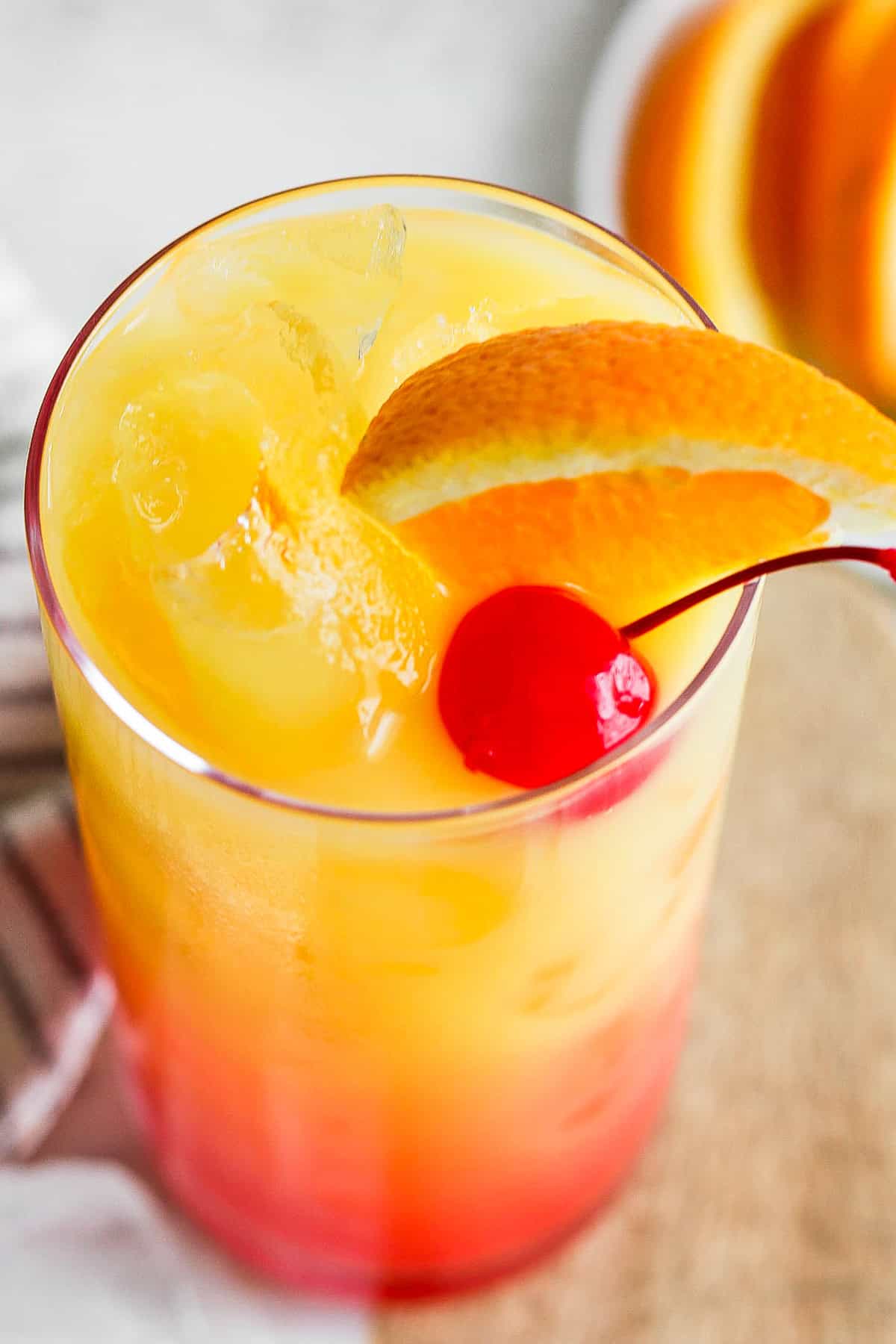 Orange slice and maraschino cherry on a tequila sunrise.