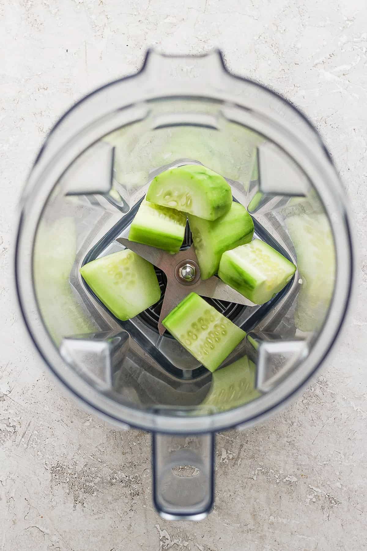 Chunks of peeled and diced cucumbers in a blender.