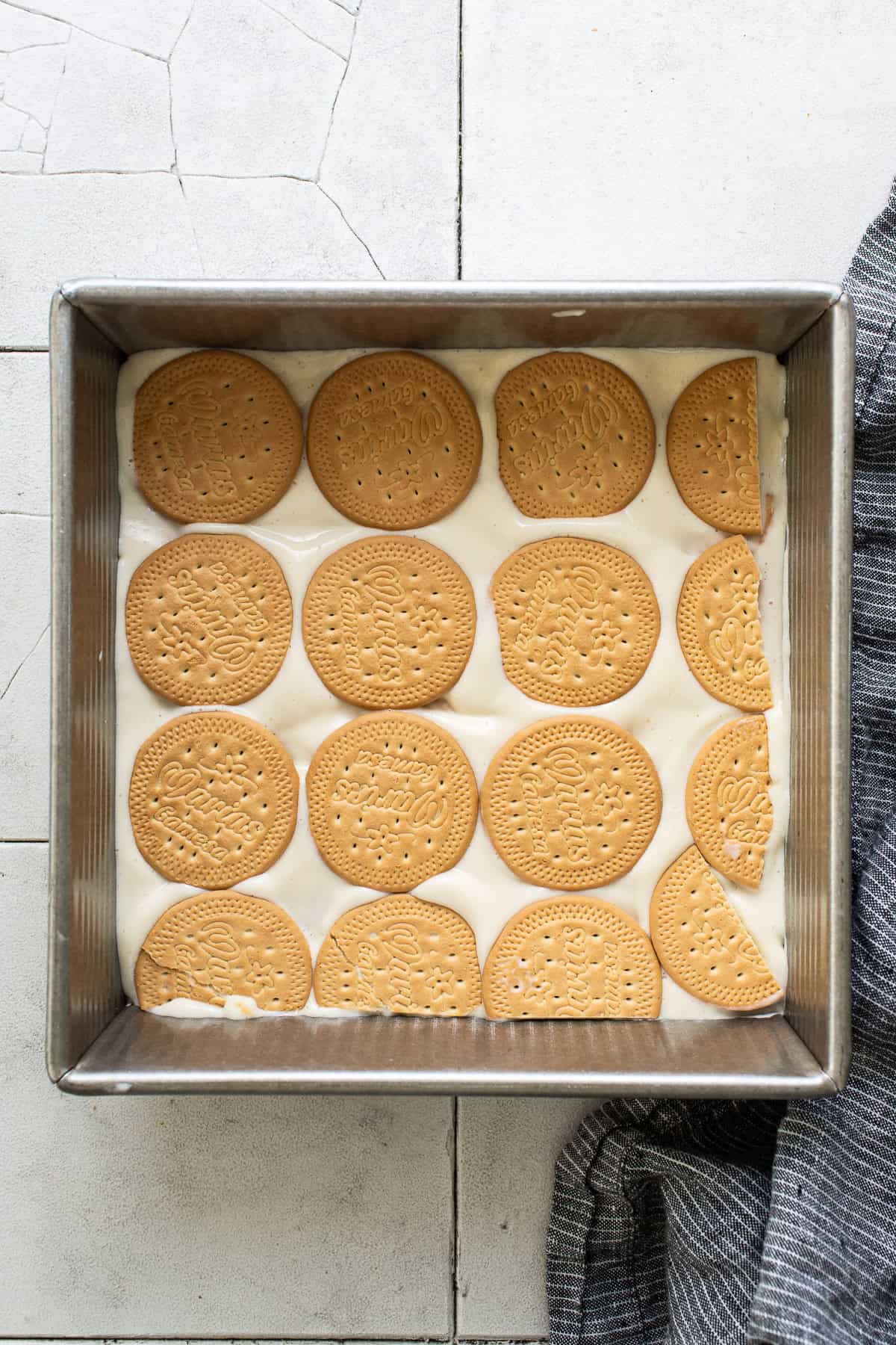 Assembled even layers of maria cookies and key lime mixture in a baking sheet