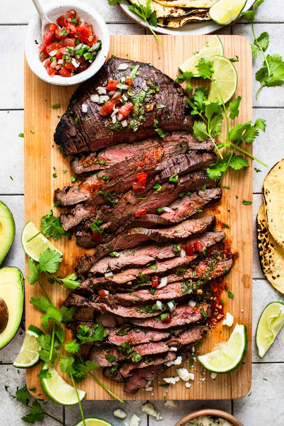 Carne Asada thinly sliced on a cutting board.