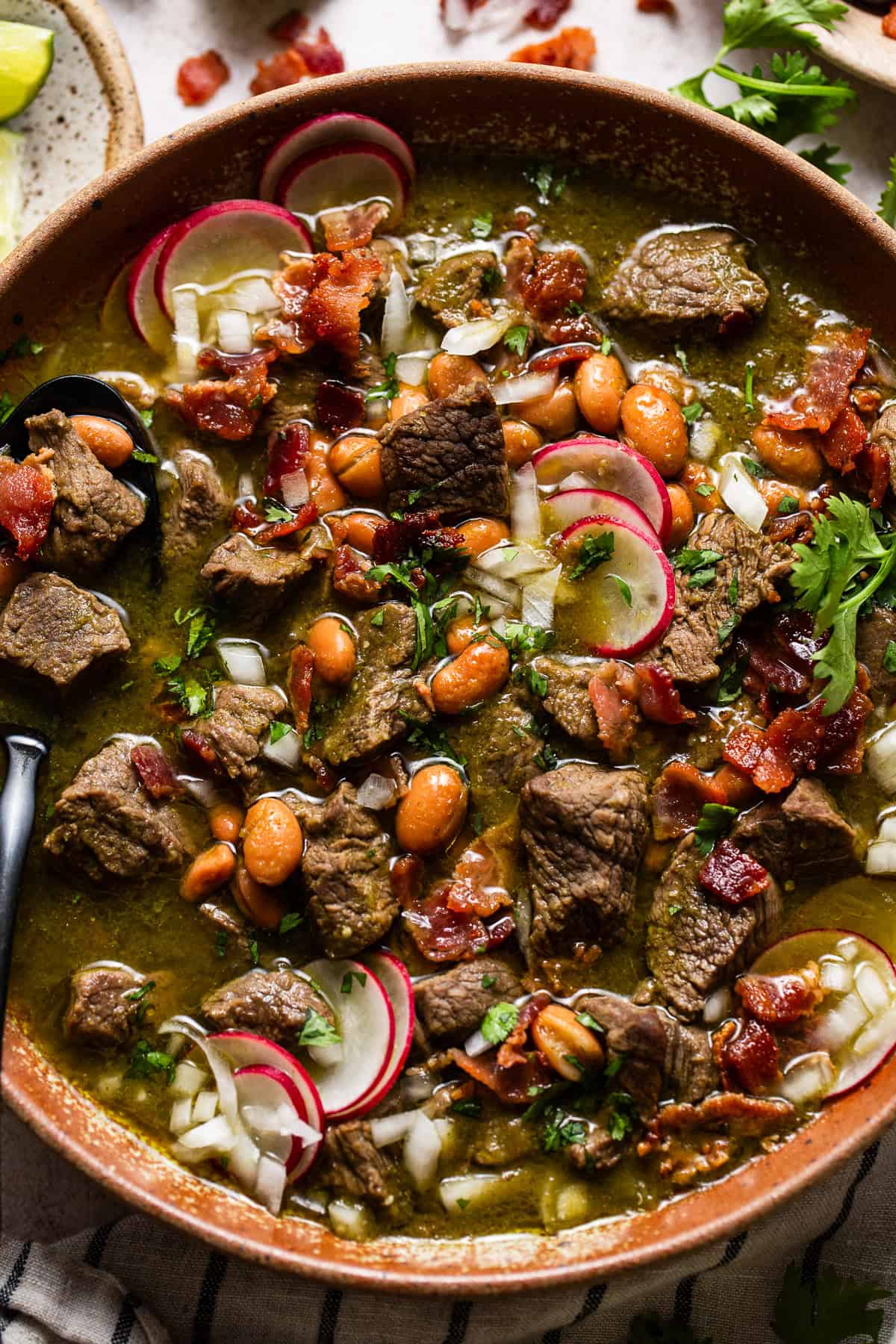 Carne en su jugo served in a bowl with toppings.