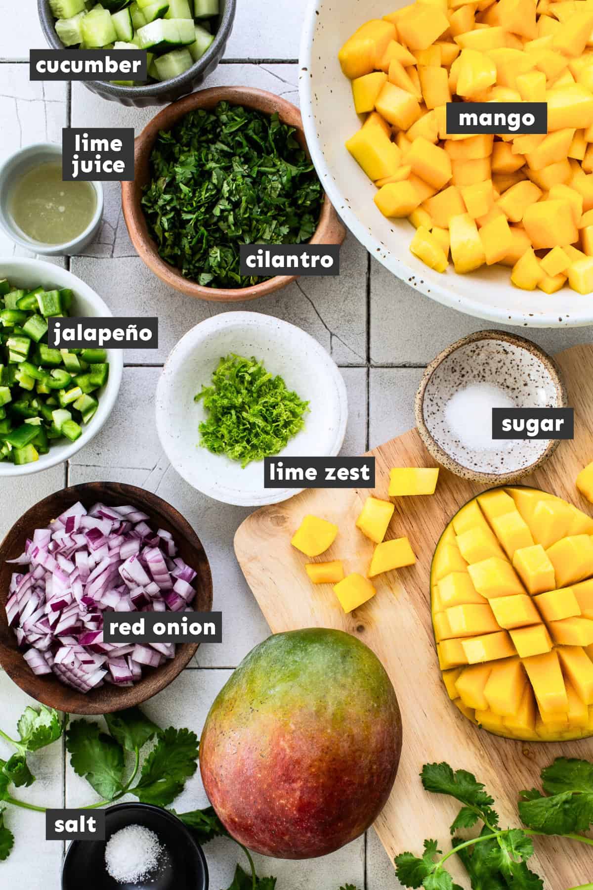 Mango salsa ingredients separated  into mixing bowls 