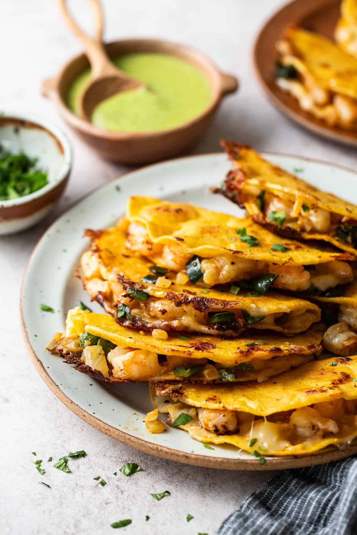 Tacos gobernador stacked on a plate with a side of salsa