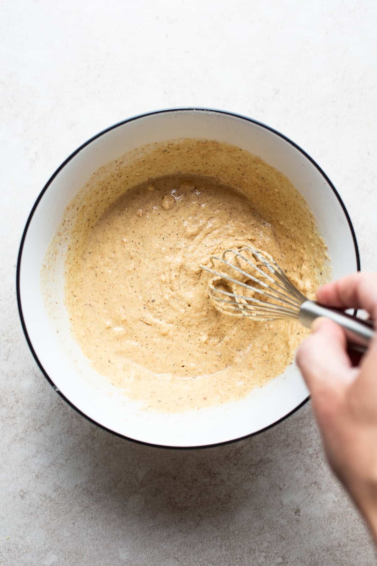 A bowl of beer-batter being whisked for coating fish.