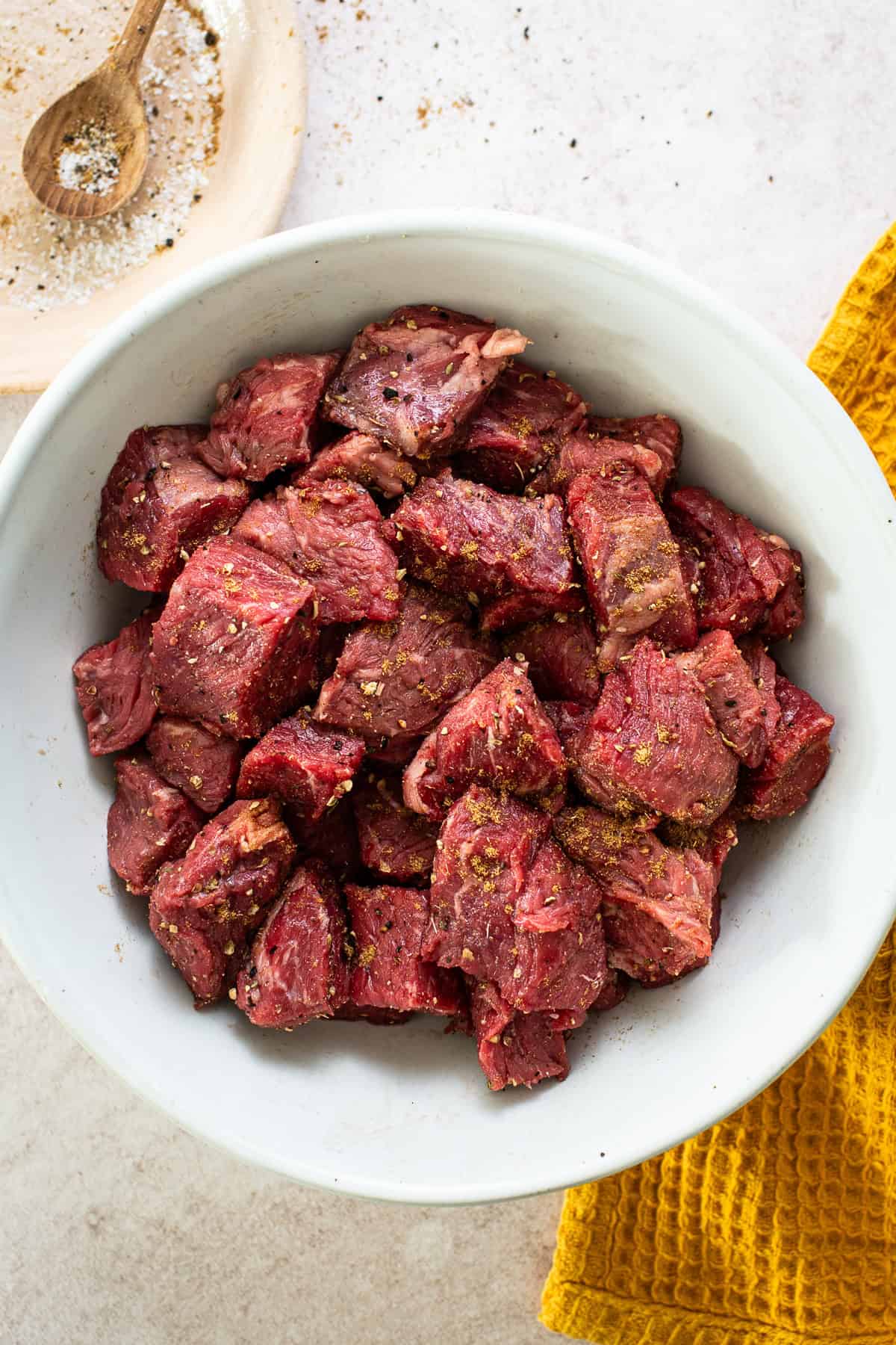 Prepared beef with seasonings on both sides in a large bowl