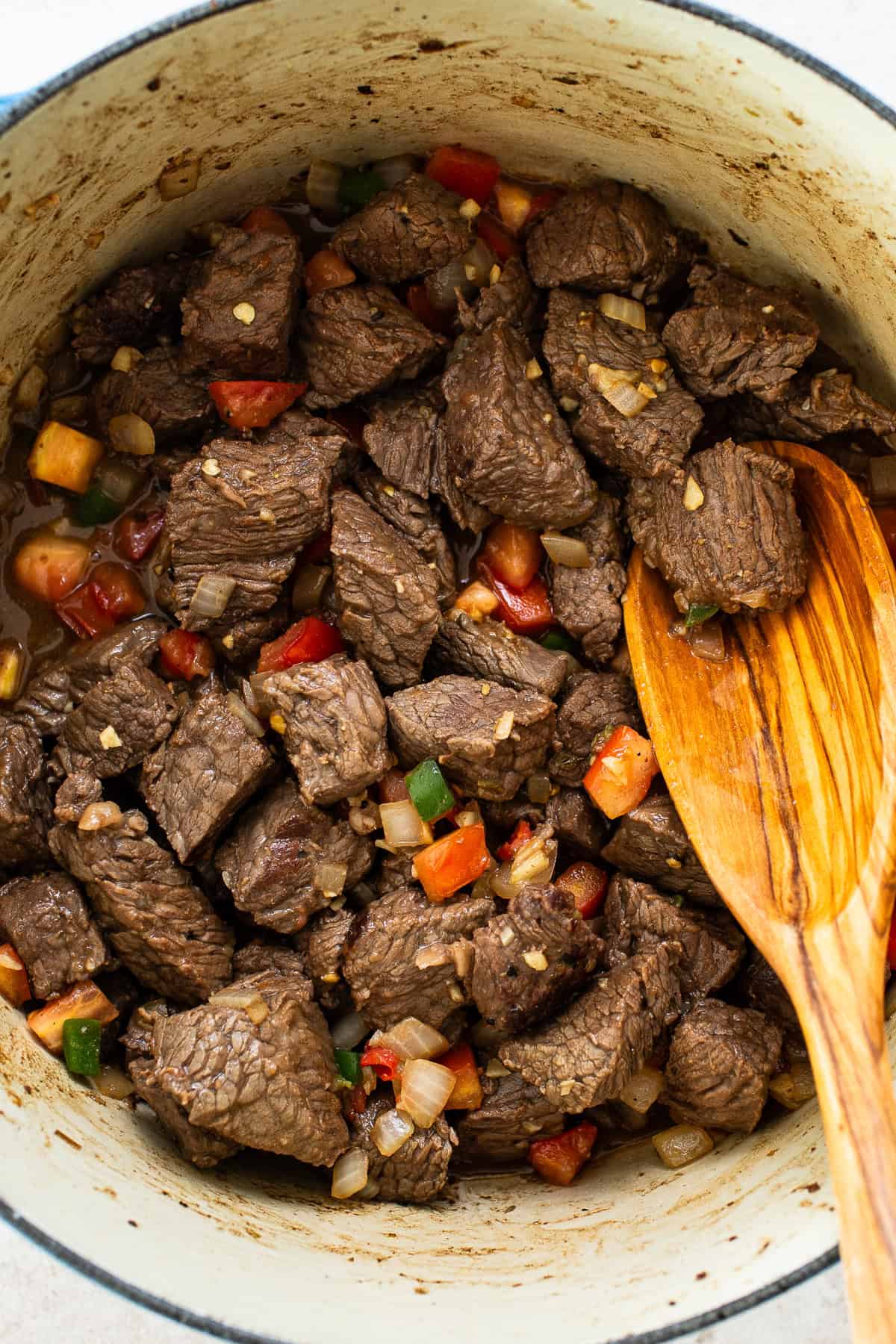 Cooked beef in a dutch oven with all seasonings and vegetables