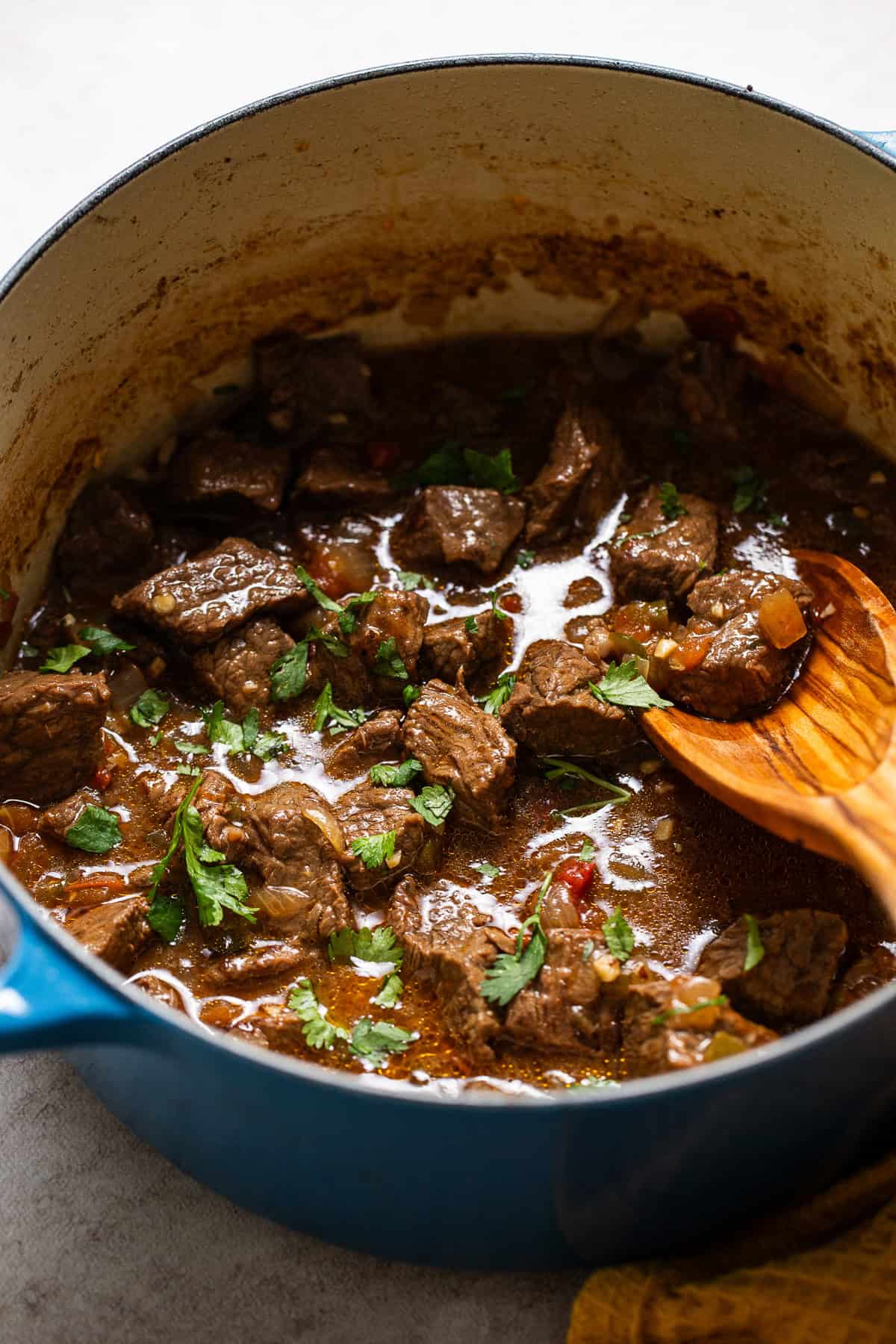 Carne guisada in the pot topped with cilantro and ready to serve