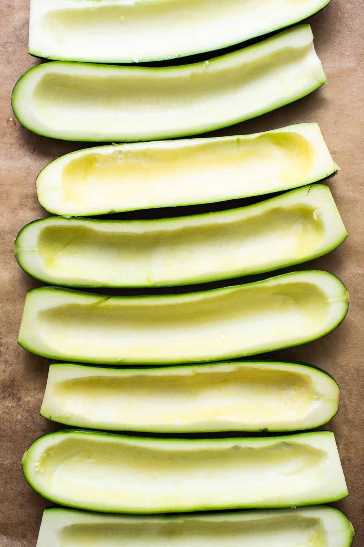 Zucchinis cut in half and seeds scooped out ready to use.