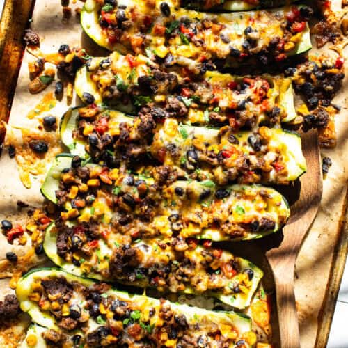 Stuffed zucchini boats filled with black beans, corn, cheese, and salsa.