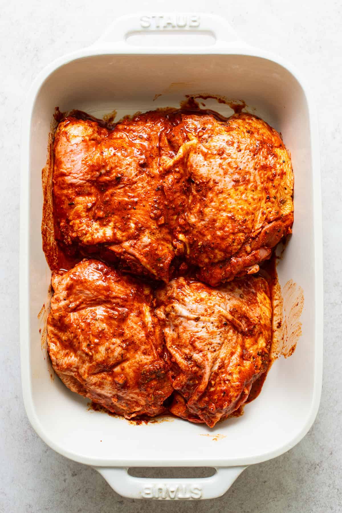 Pollo asado marinating in a baking dish.