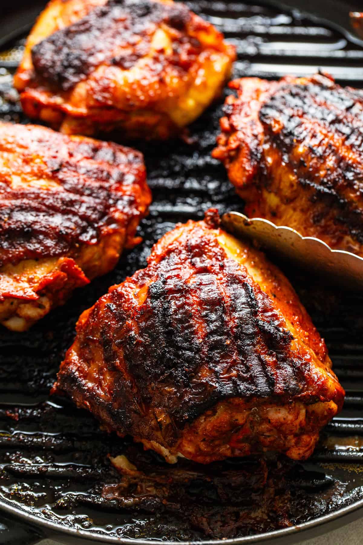 Pollo asado grilling on a grill pan.