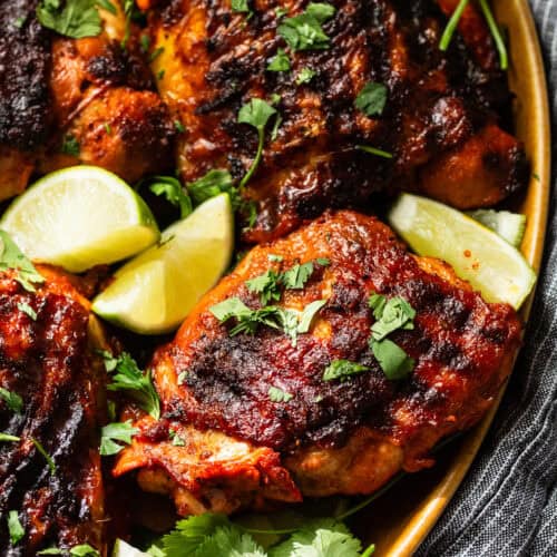 Pollo asado with grill marks on a plate and garnished with cilantro.