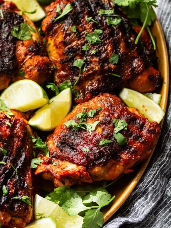 Pollo asado with grill marks on a plate and garnished with cilantro.