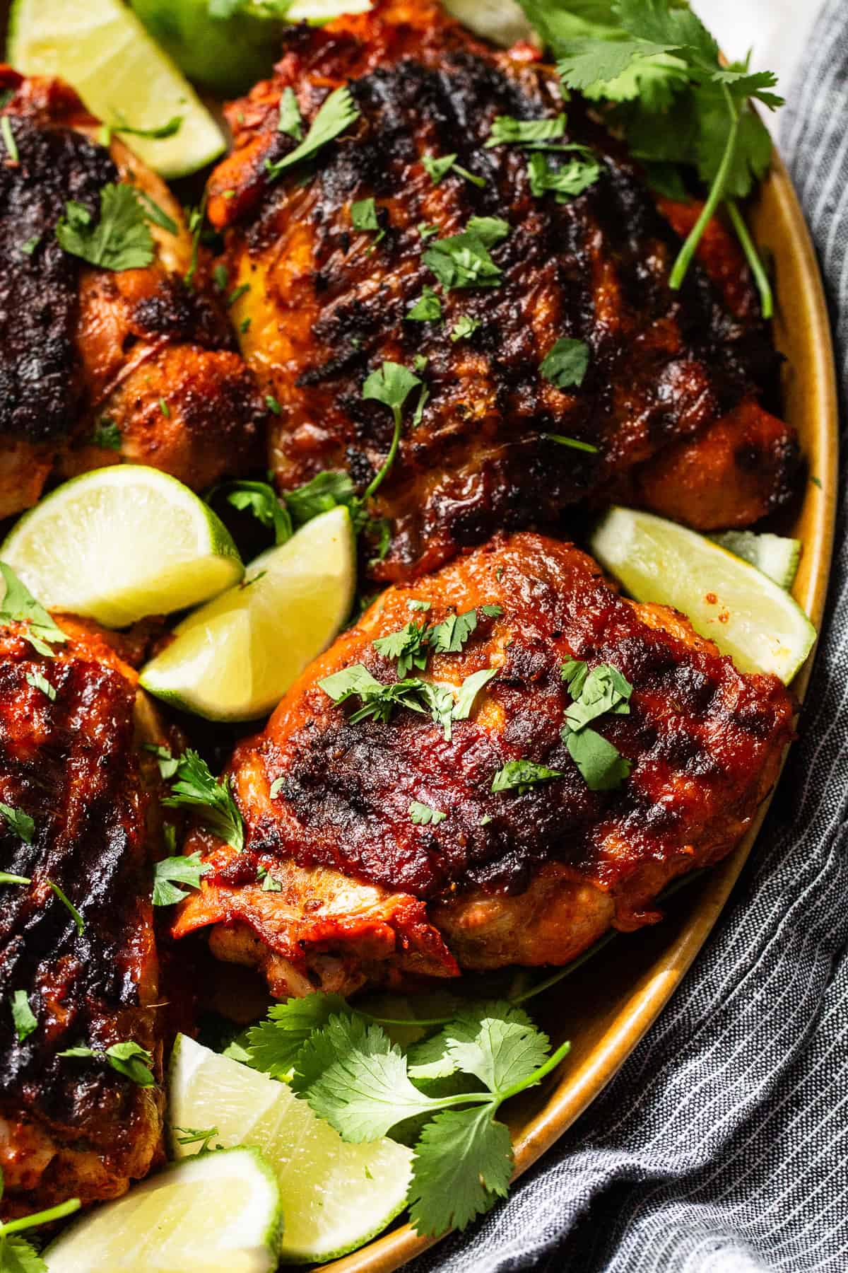 Pollo asado with grill marks on a plate and garnished with cilantro.