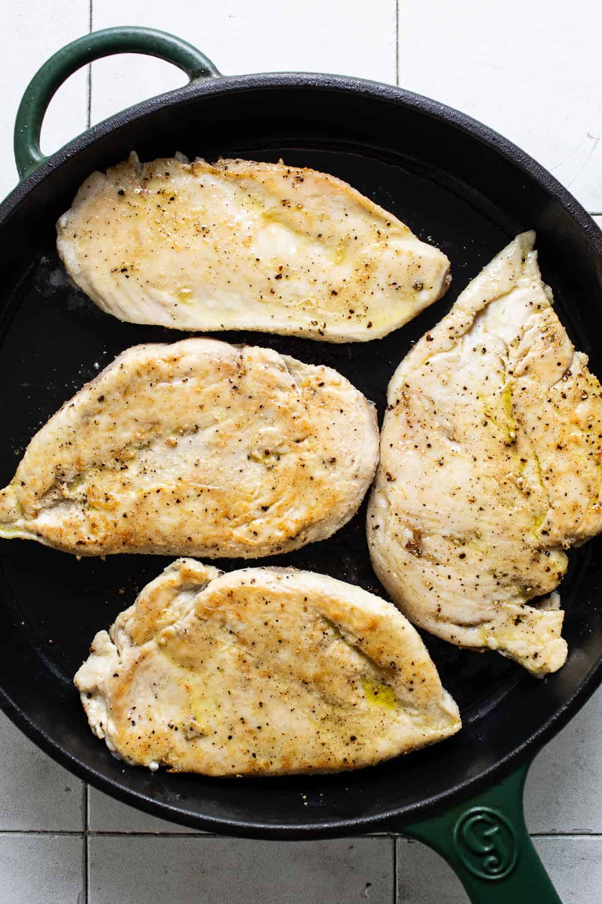 Seared chicken breast in a skillet.