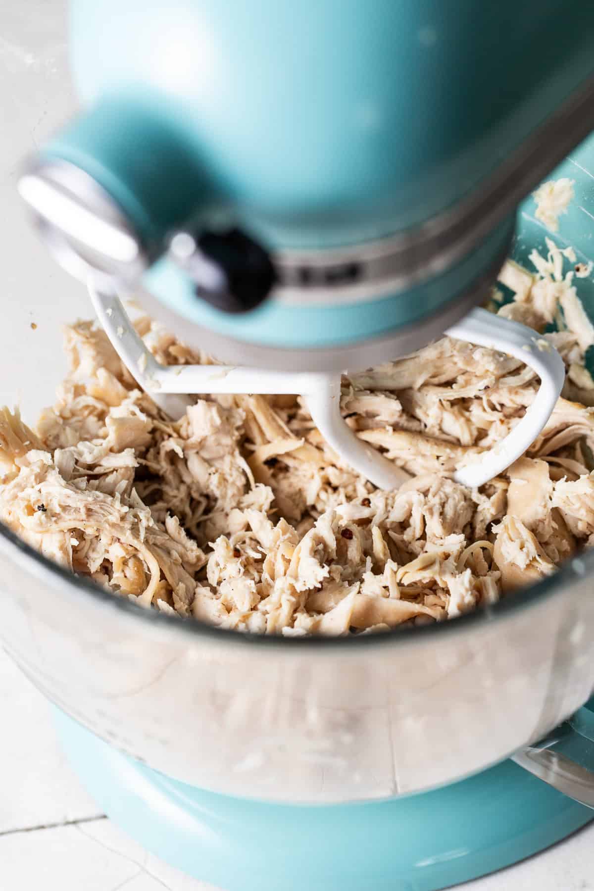 Shredded chicken in a stand mixer.