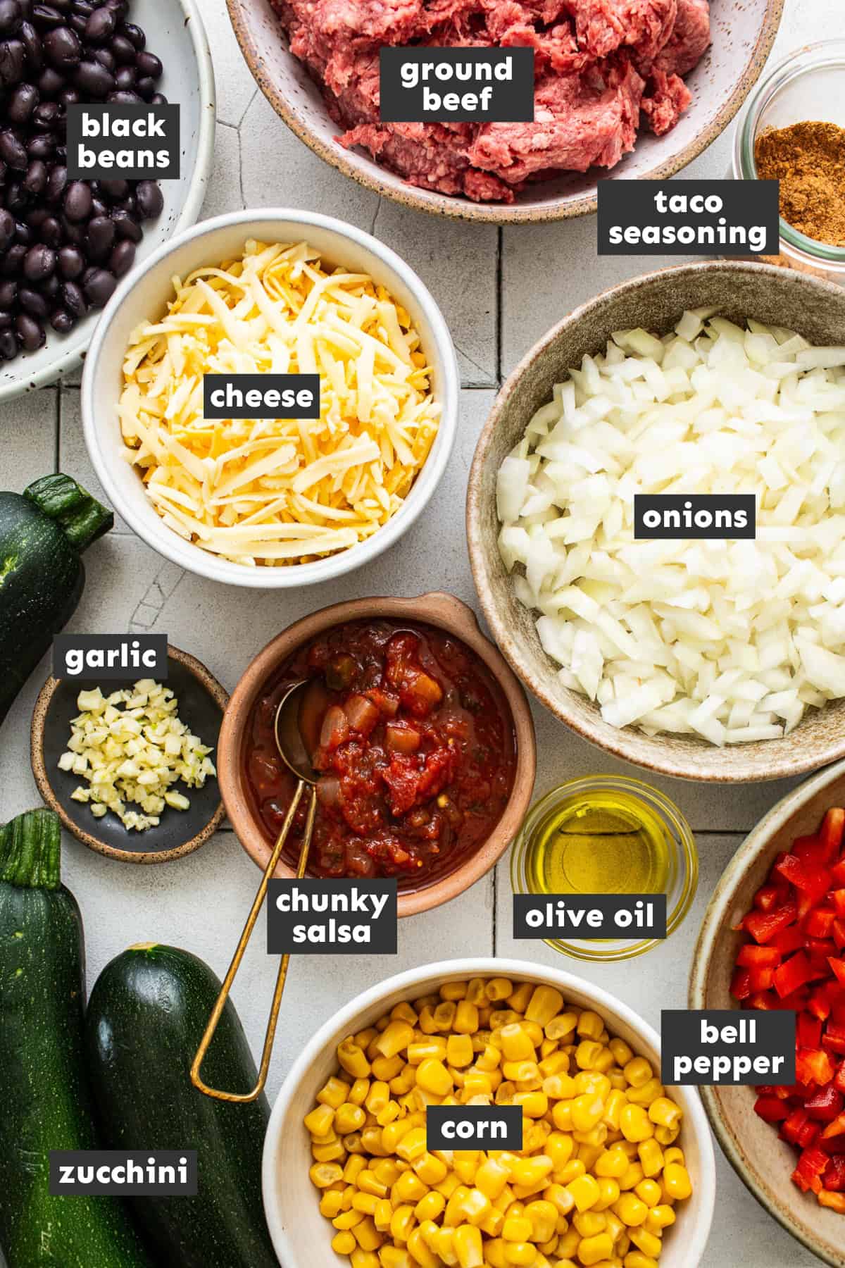 Ingredients for stuffed zucchini boats on a table.