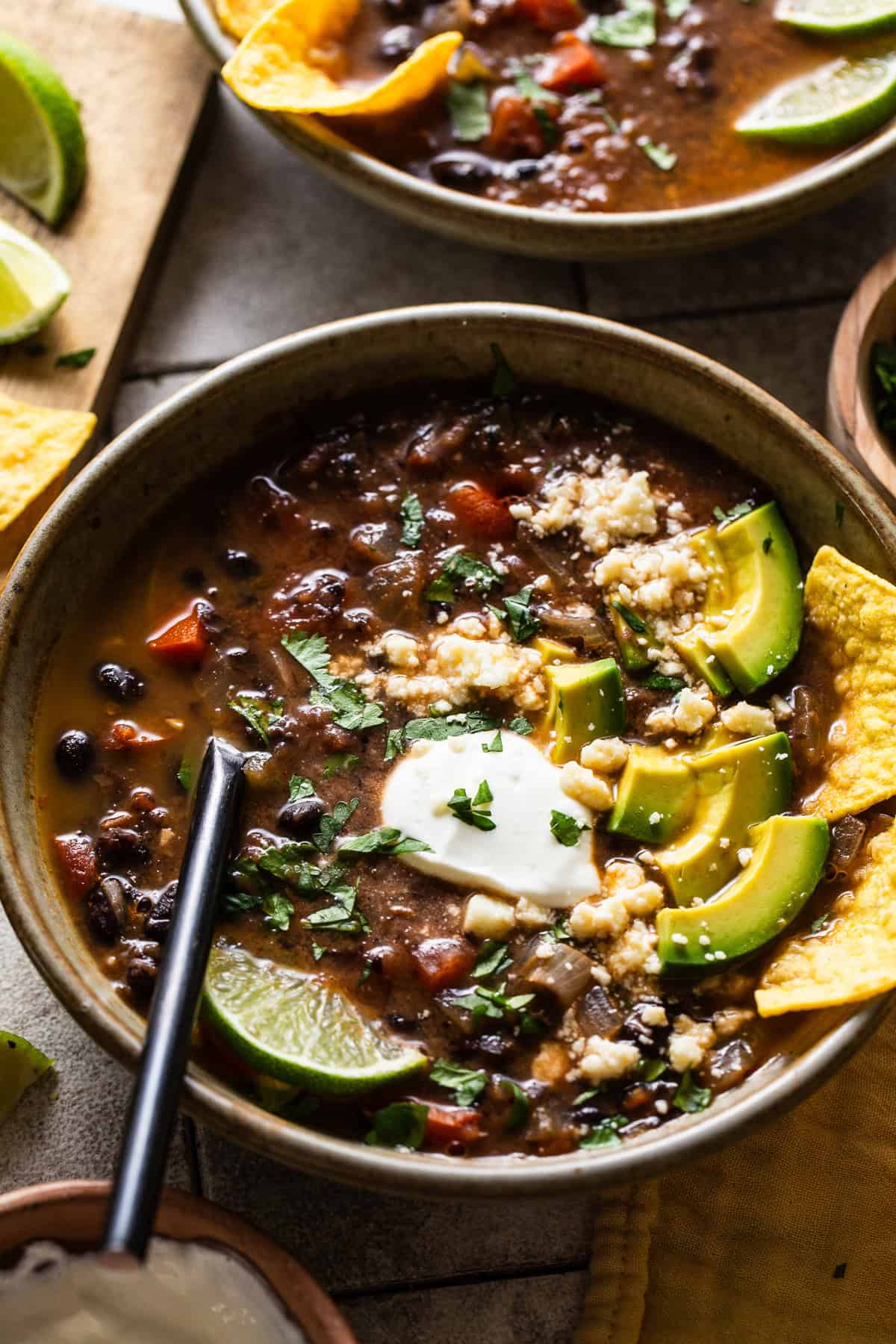 Healthy black bean soup served with tortilla chips on the side.