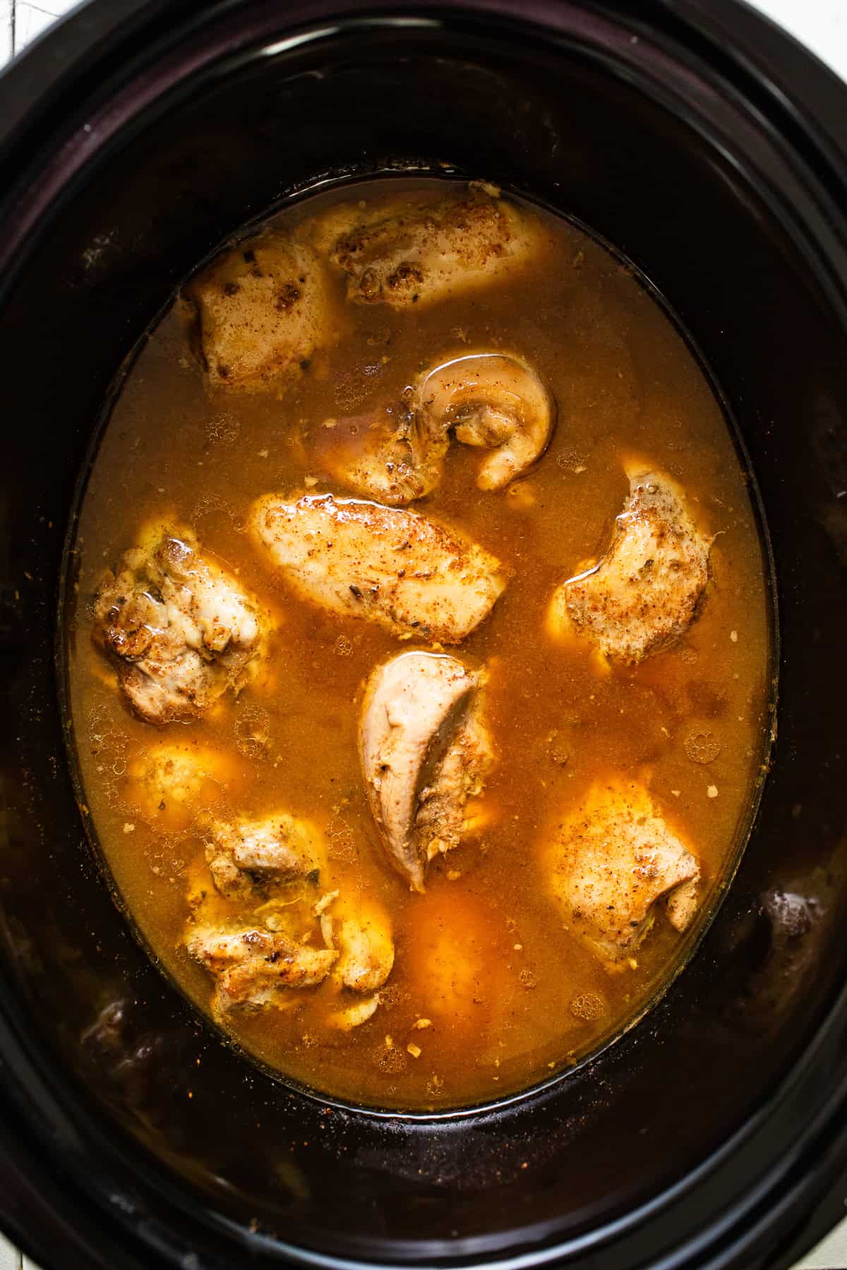 Cooked chicken carnitas inside the crockpot.