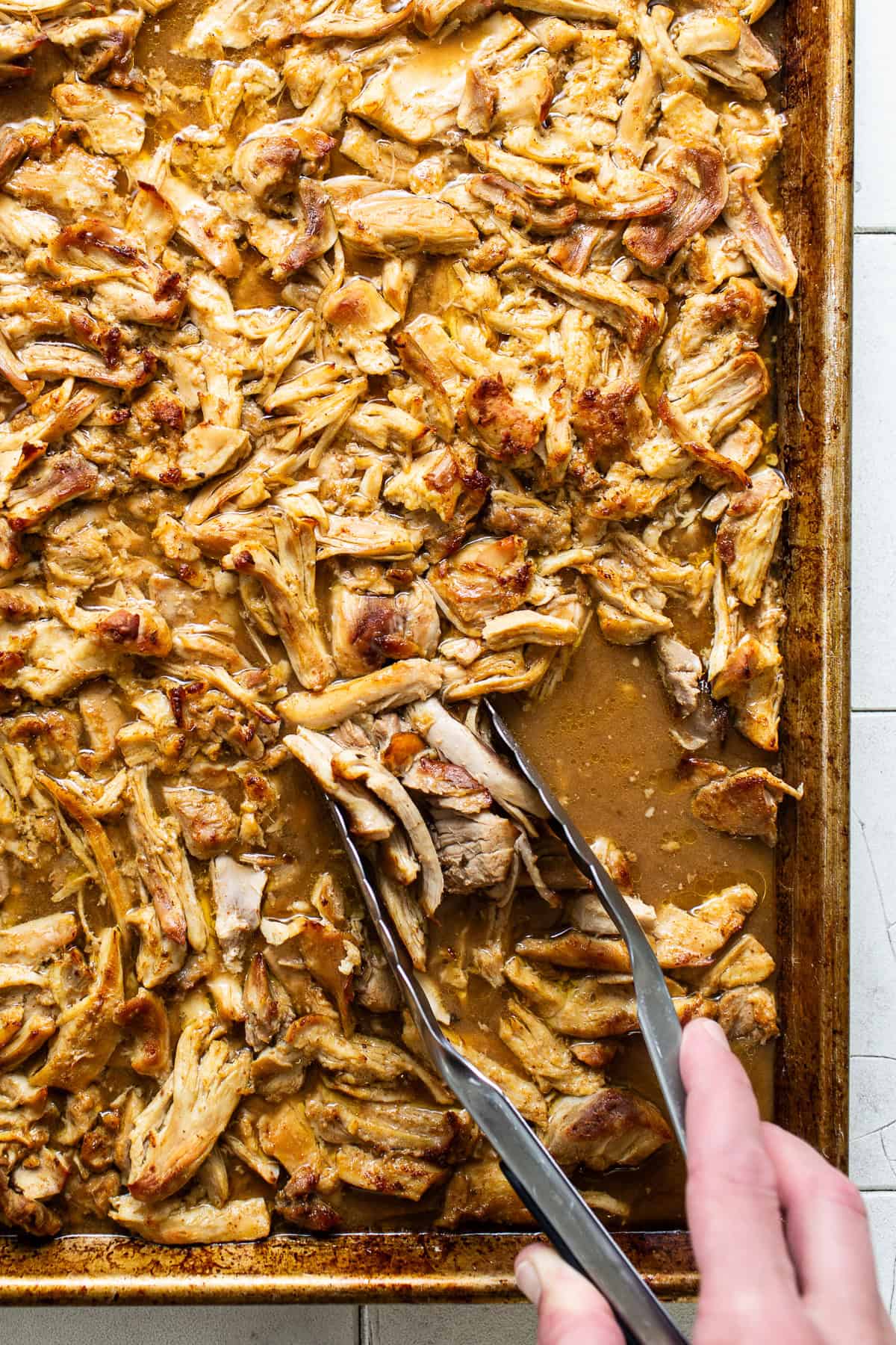 Cooked shredded chicken carnitas on a baking sheet ready to eat. 