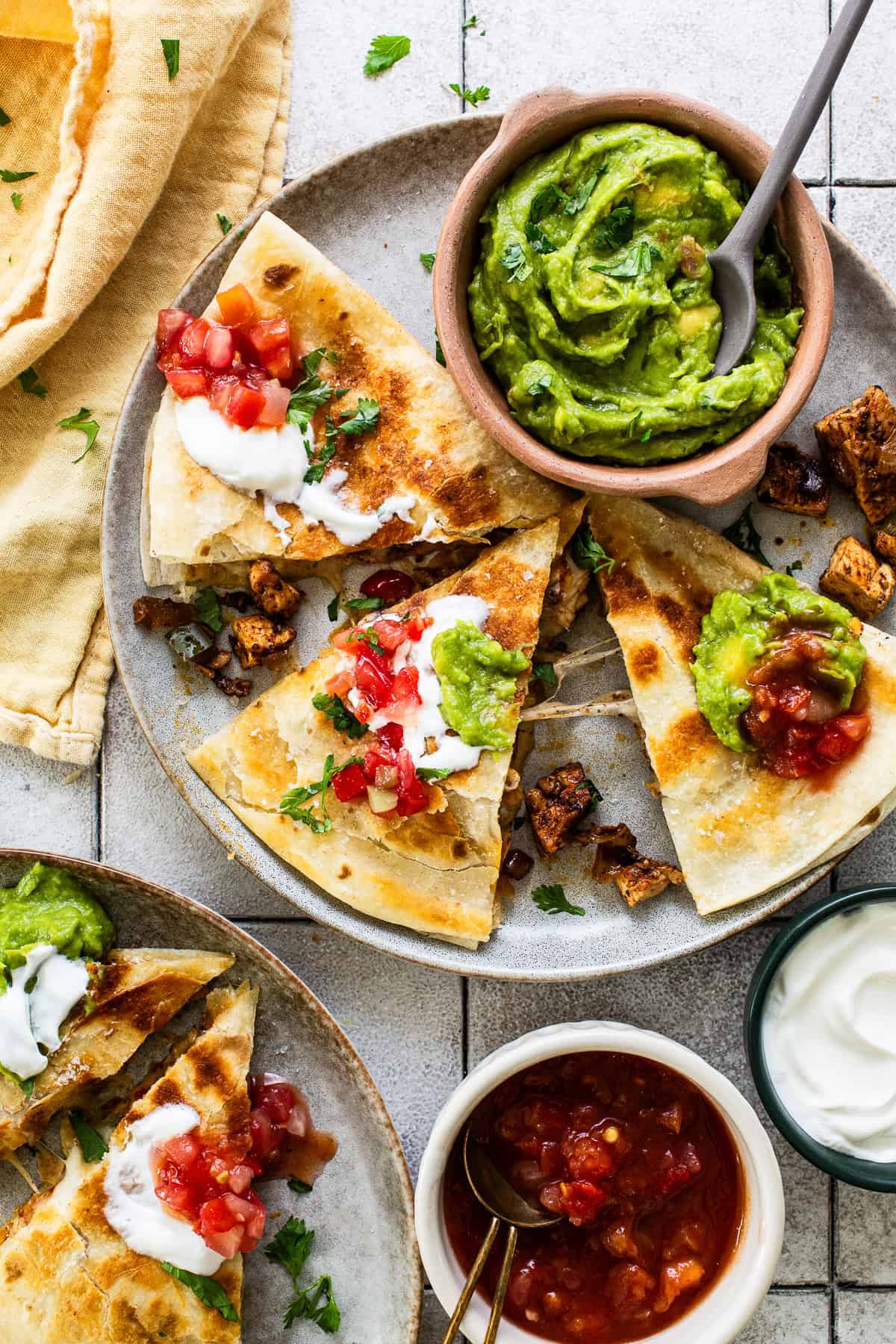 Ready to eat chicken fajita quesadillas cut into triangles and served on a plate.