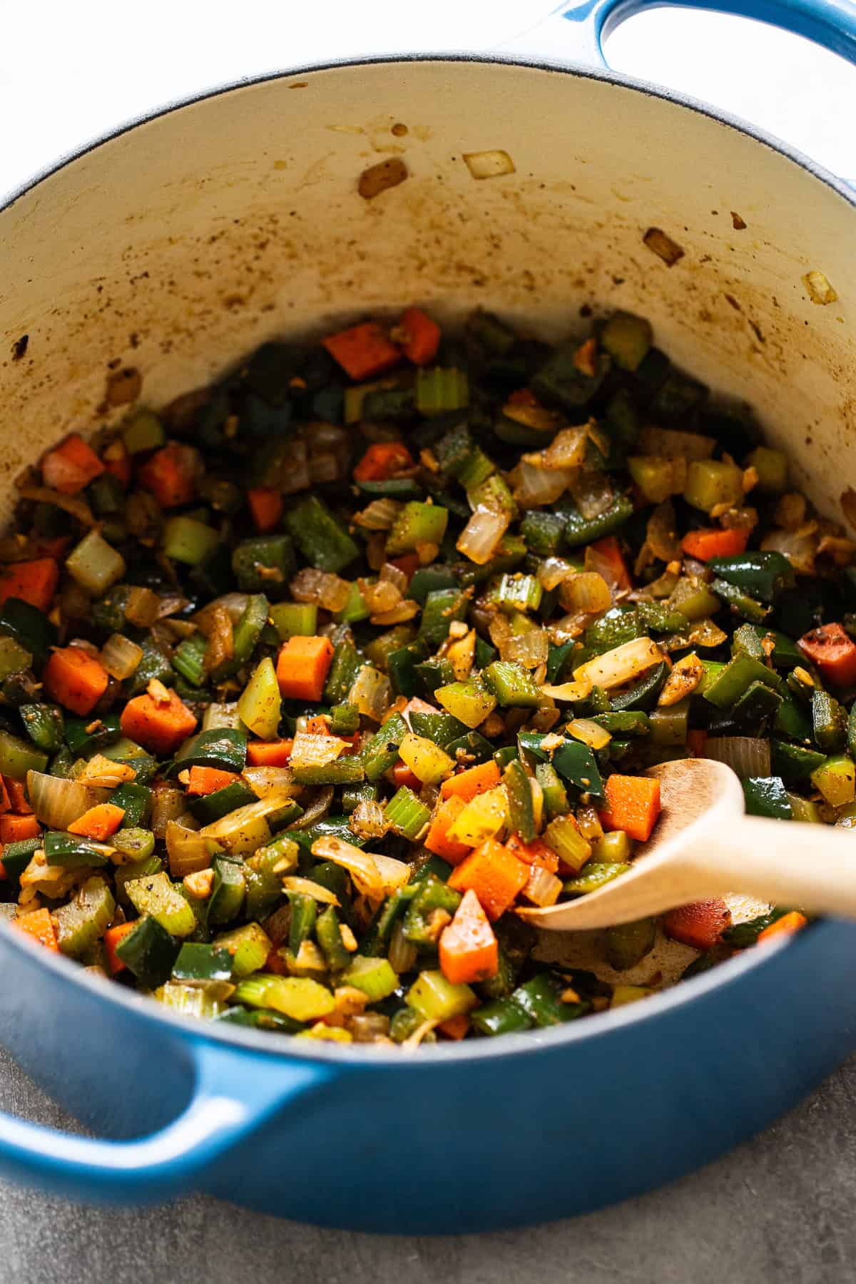 Dutch oven filled with sauteed vegetables and garlic.