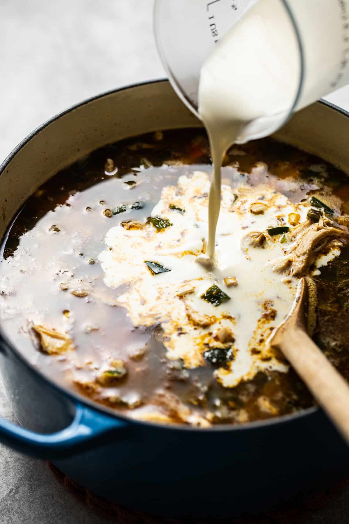 A large bowl filled with chicken poblano soup on a table. 