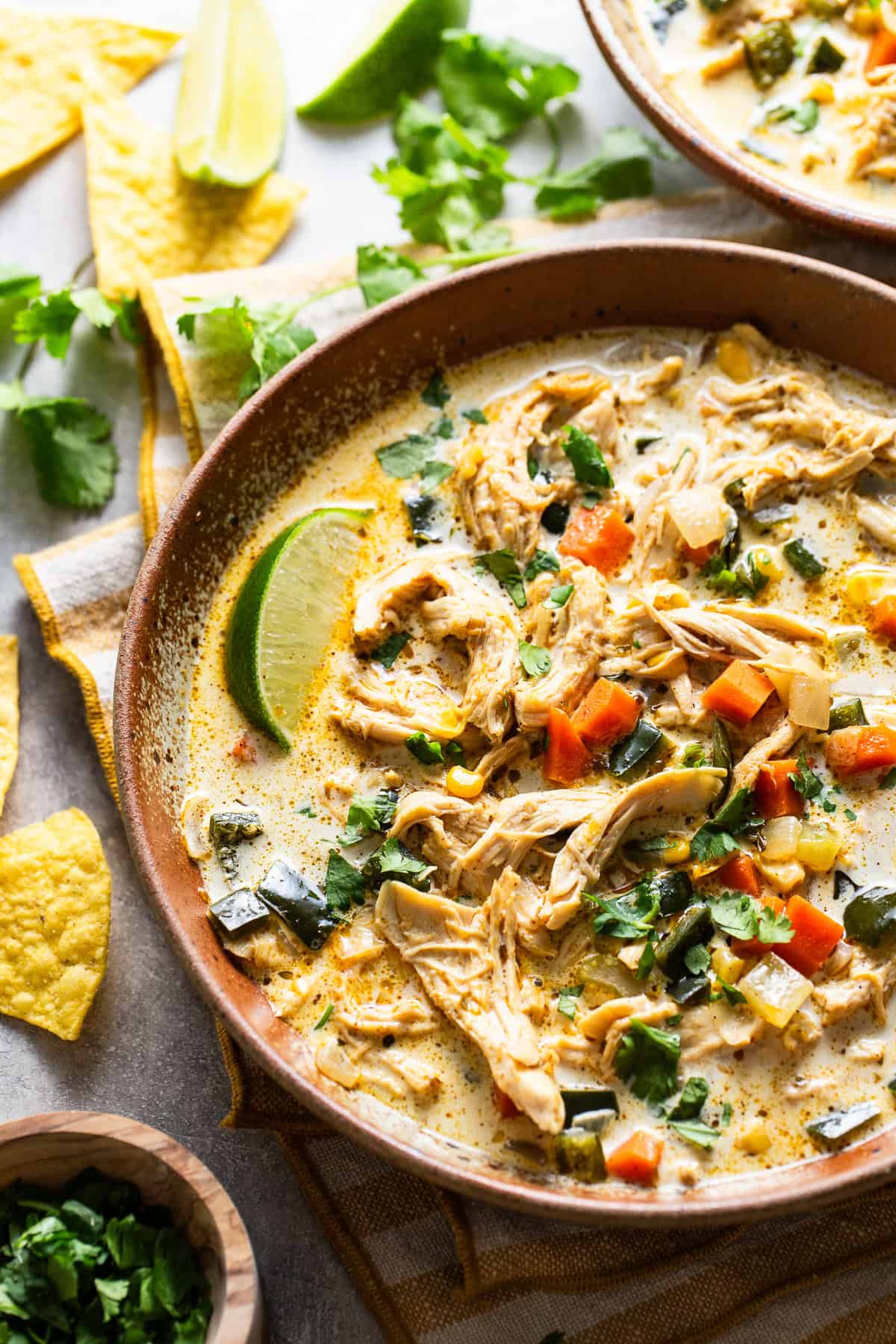 Creamy chicken poblano soup served with tortilla chips in a bowl.