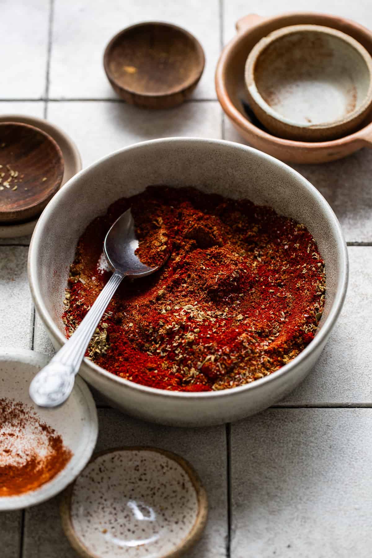 Dried spices mixed together in a bowl before being added to ground pork to make a chorizo recipe.