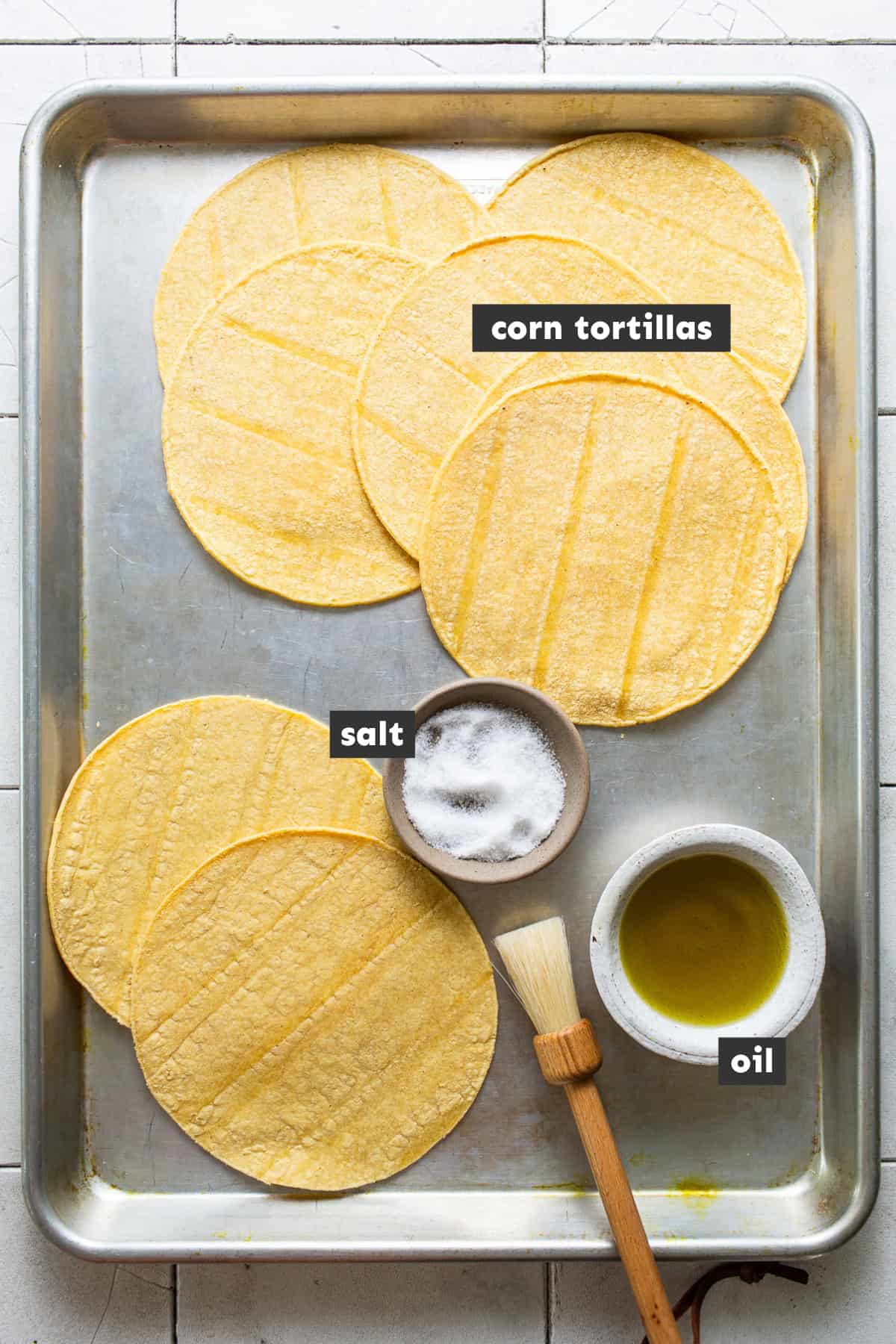 Ingredients for tostada shells laid out on a baking sheet ready to use. 