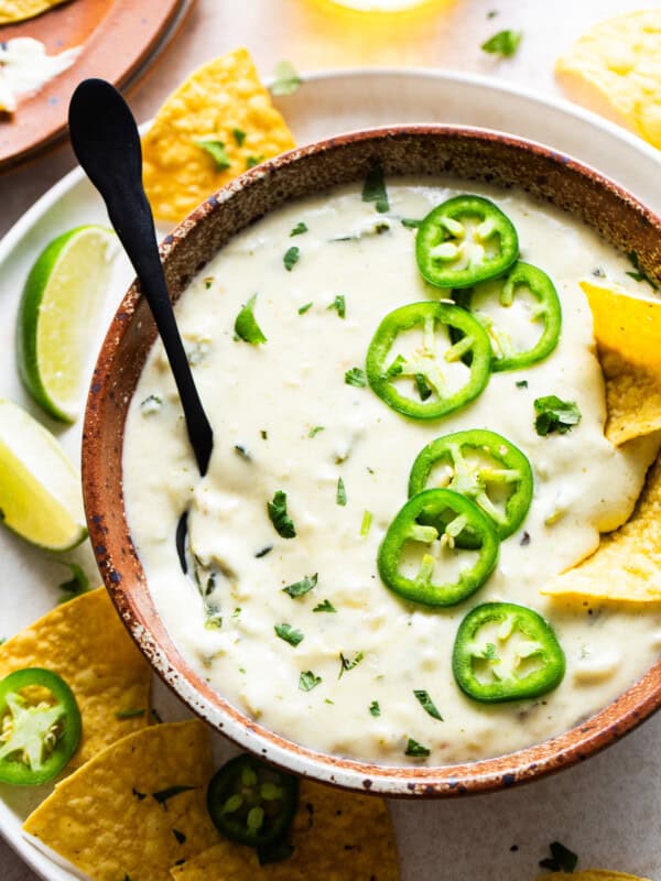 Salsa Verde Queso dip in a bowl served with tortilla chips.