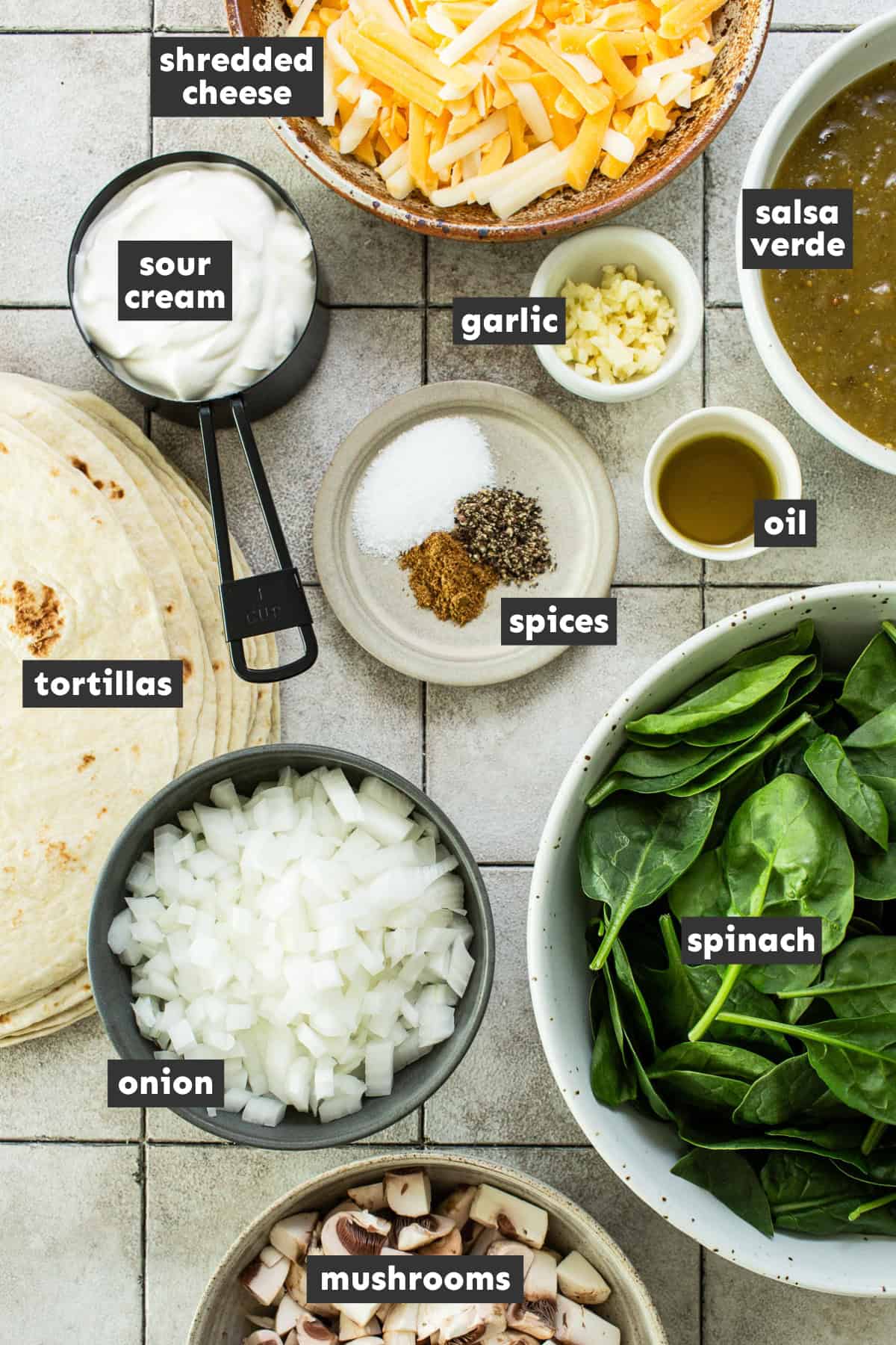 Ingredients for spinach enchiladas laid out on a table ready to use.