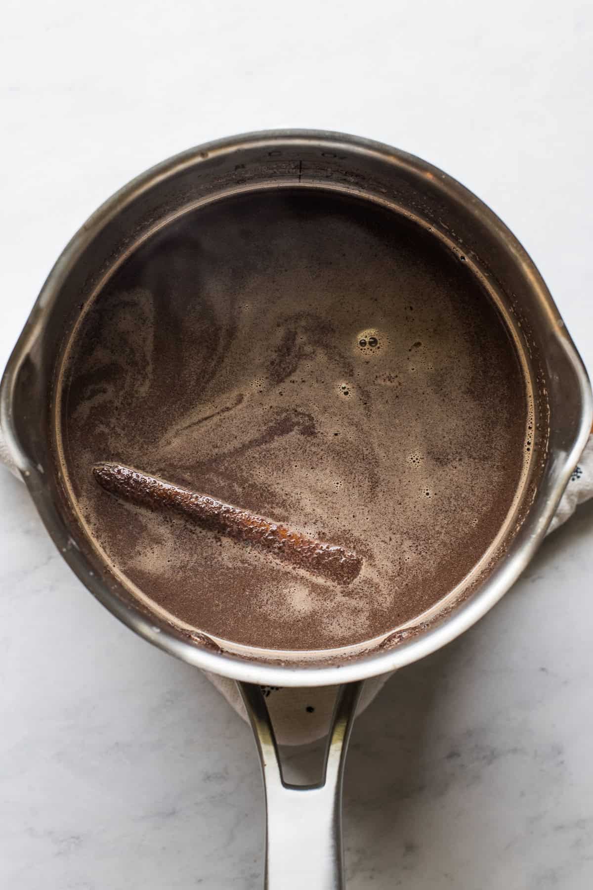 Milk and Mexican chocolate mixture heating in a saucepan until completely dissolved.