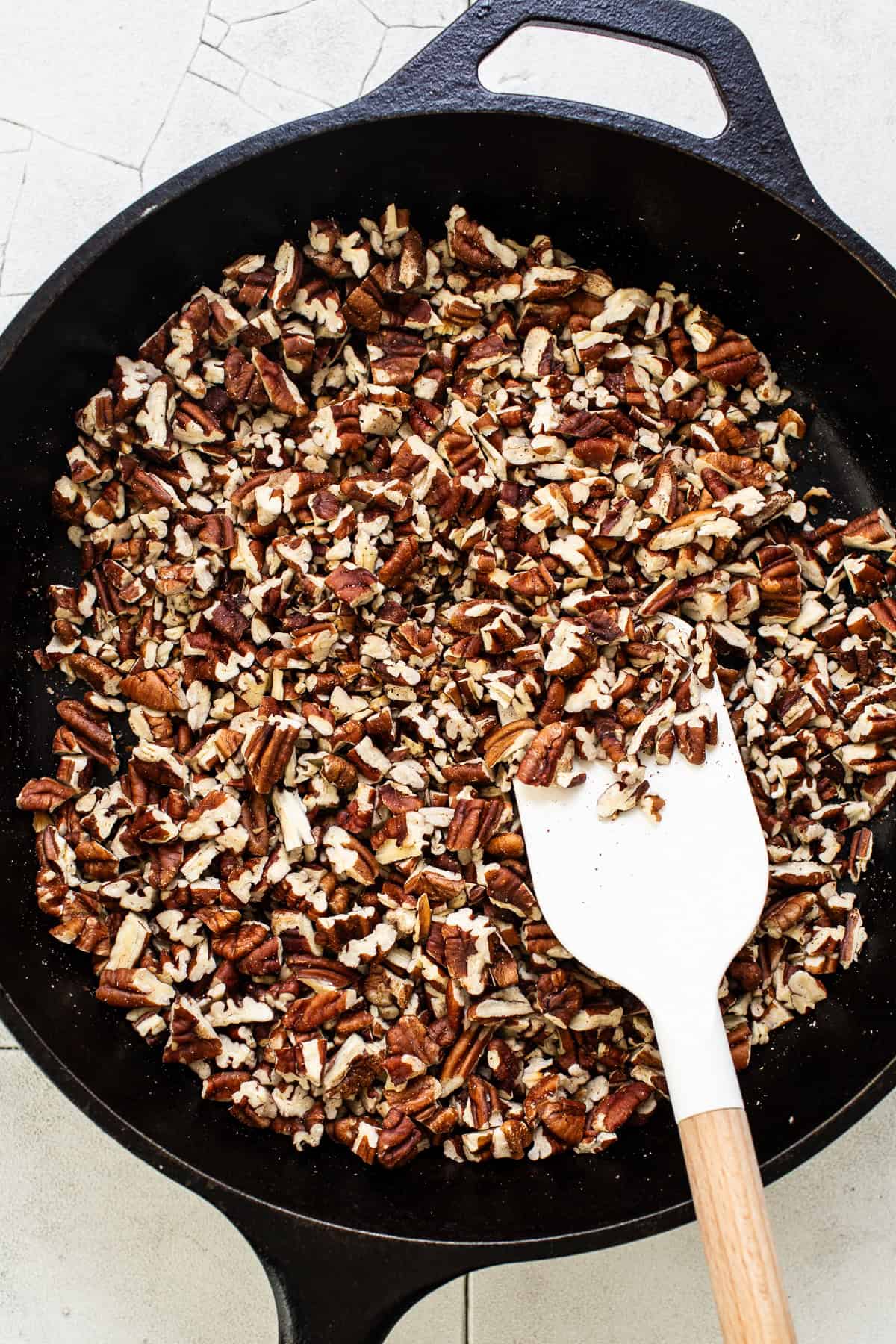 Pecans toasting in a large skillet.