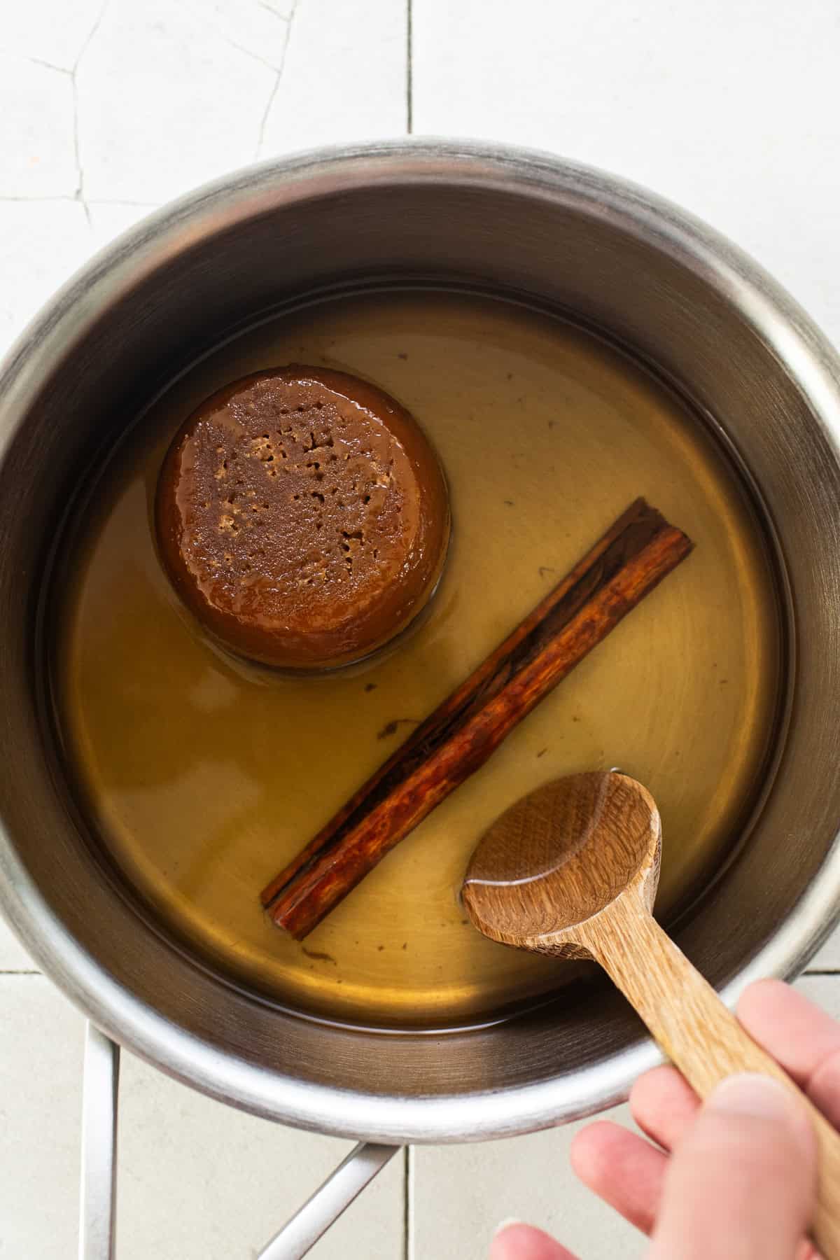 A small pot with water, cinnamon, and piloncillo.