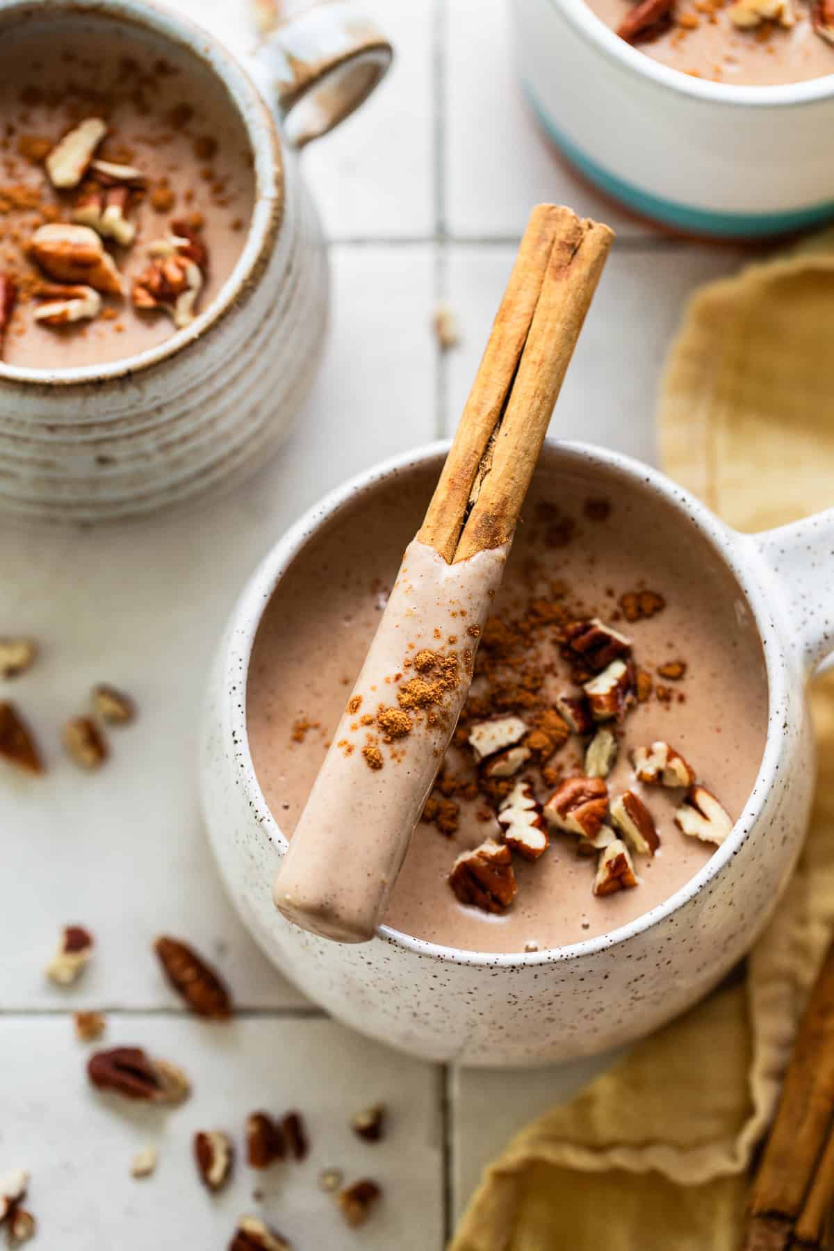 Atole de nuez in a mug with a cinnamon stick.