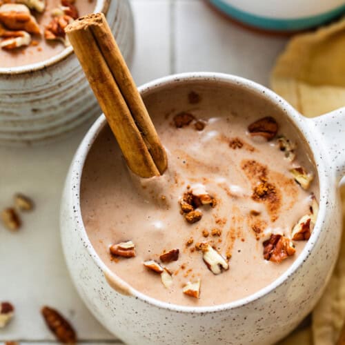 Atole de nuez in a mug with a cinnamon stick.