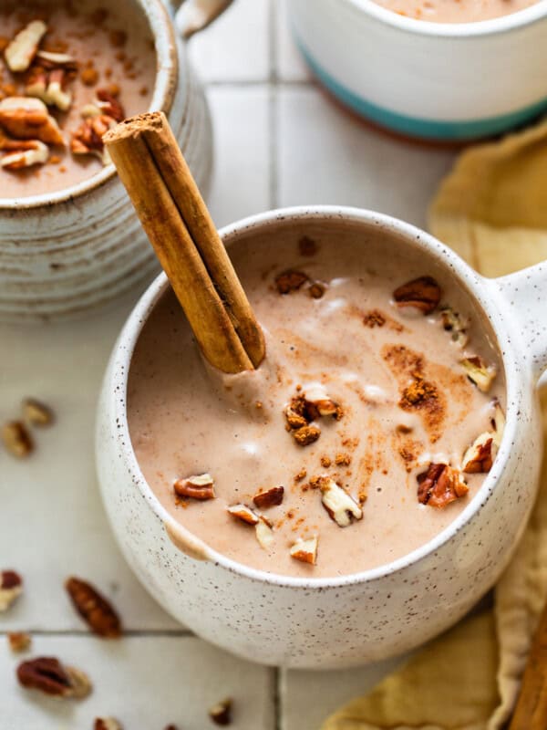 Atole de nuez in a mug with a cinnamon stick.