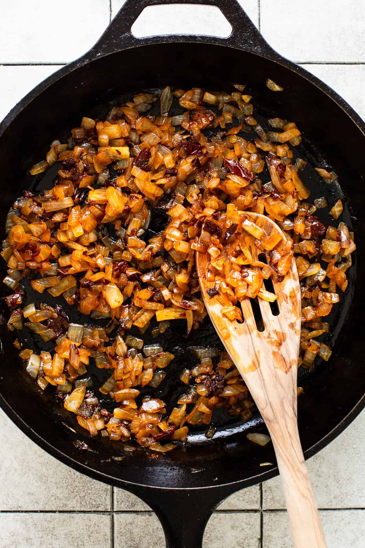 Sauteed onions and chipotle peppers in adobo sauce in a cast iron skillet.