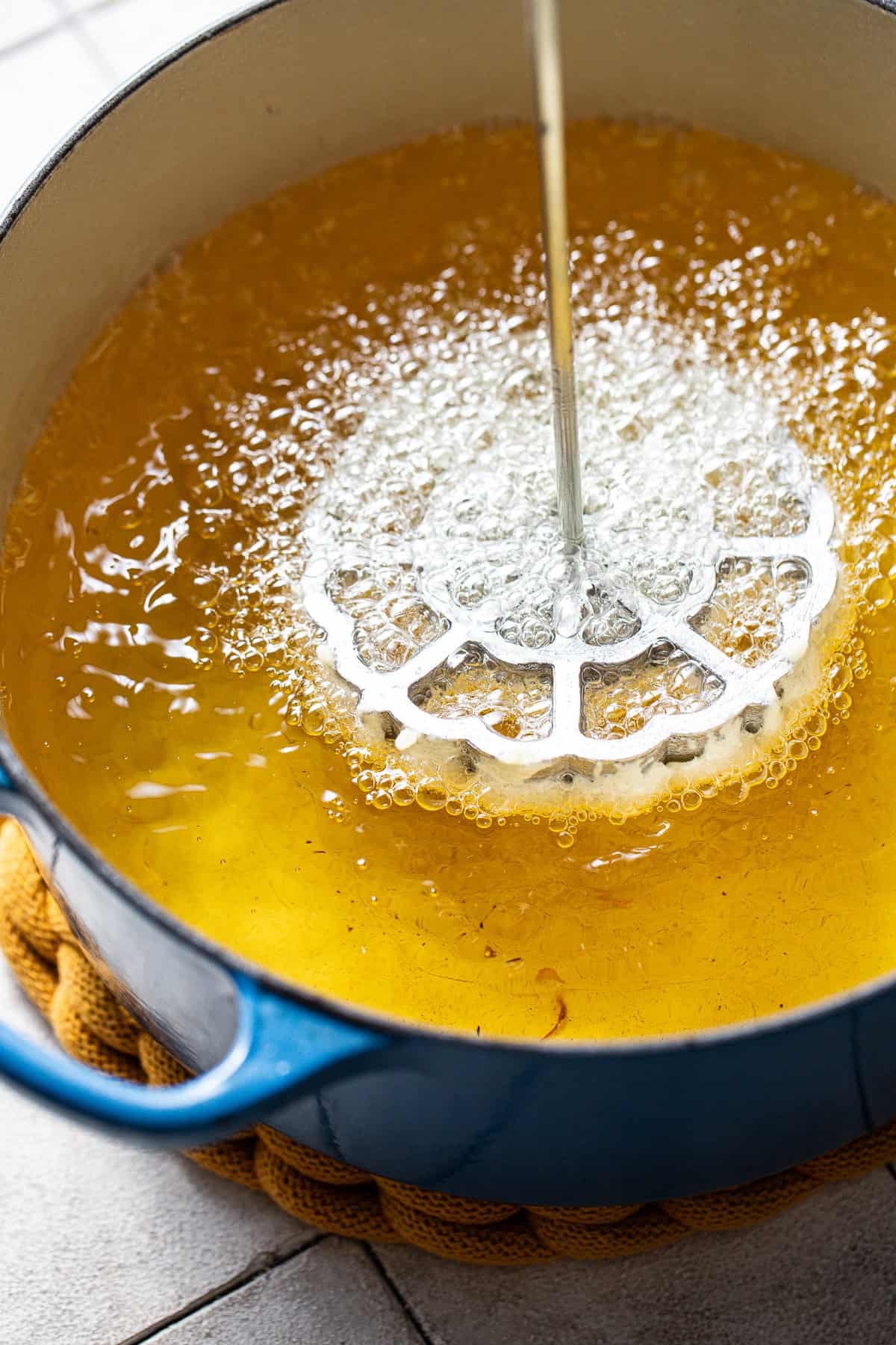 Buñuelos de viento being fried in oil.