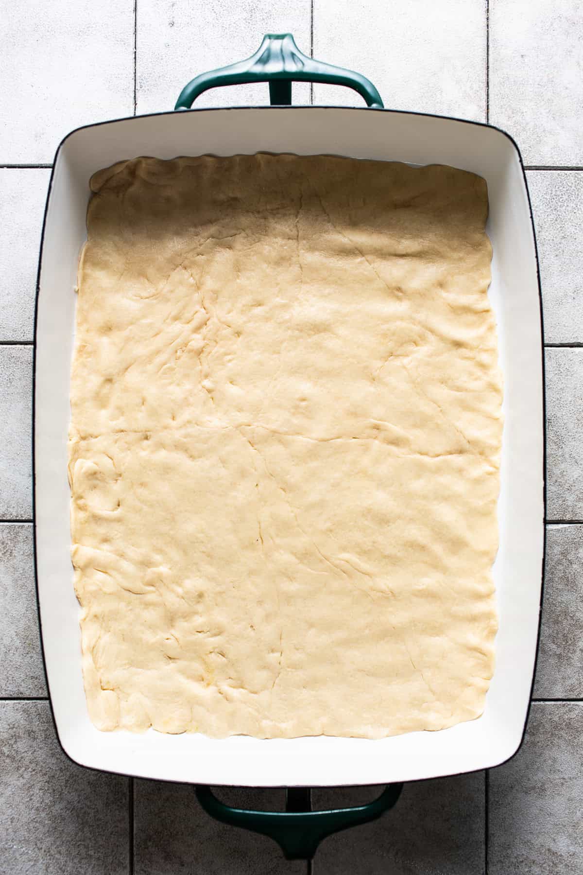 Crescent roll dough pressed into one sheet onto the bottom of a large baking dish.